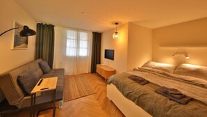 Una camera da letto moderna con divano, letto, scrivania e televisione.