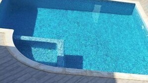 Ein Schwimmbecken mit gefliestem Sonnendeck.