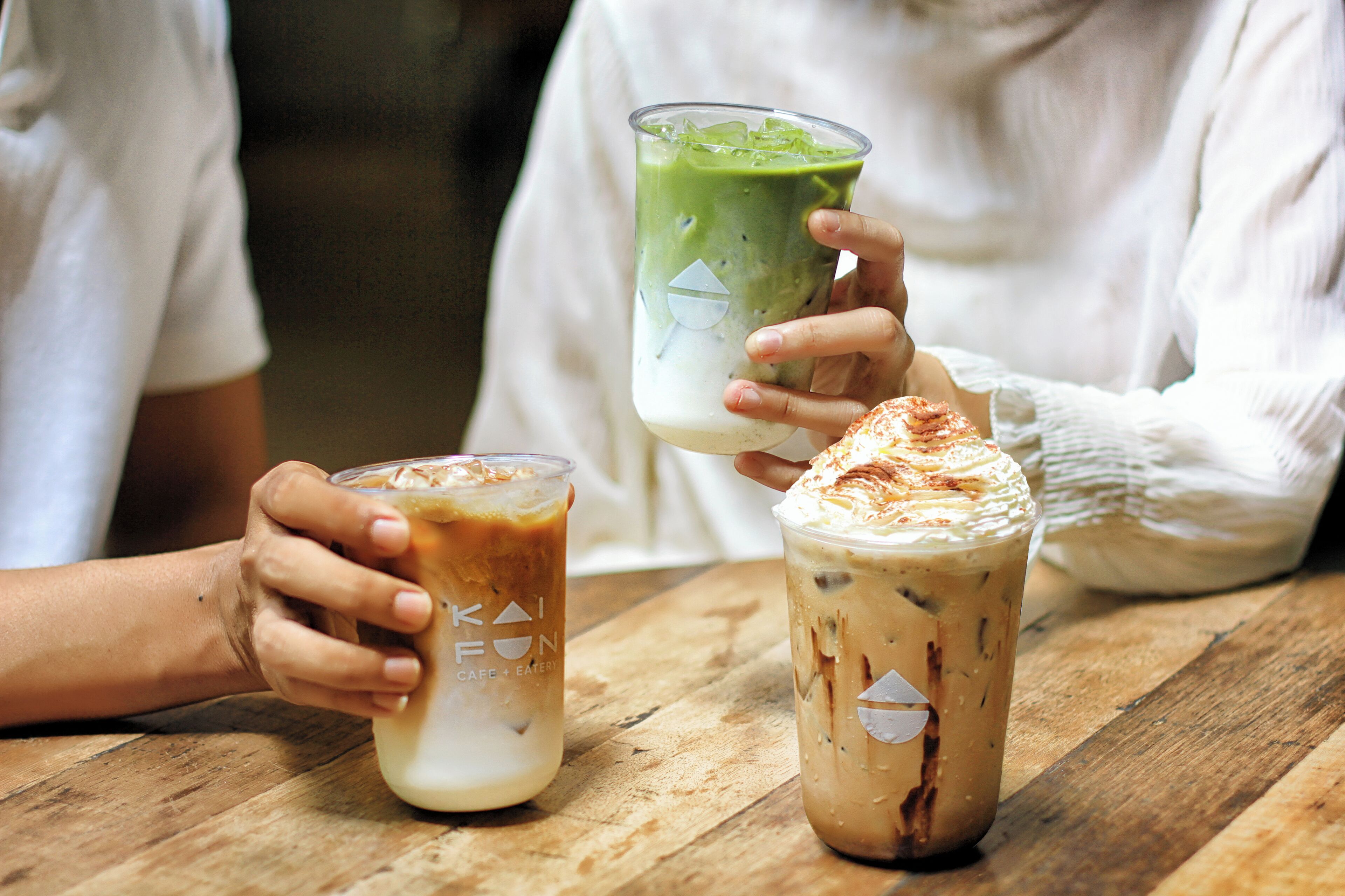 Trois boissons glacées sur une table en bois.