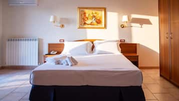 Camera d'albergo con un letto grande, due comodini, una panca da notte, un quadro appeso alla parete e un armadio.