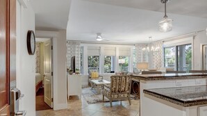 A spacious kitchen with a large island, a dining area with a table and chairs, and a view of the outdoors through large windows. - Bayview Luxury: Sandestin Retreat, Resort Perks (Miramar Beach)