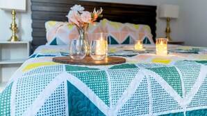 A neatly made bed with a colorful quilt, a vase with flowers, and candles on a tray. - Near Coffee/Food, NOOGA NOOK 10 mins Chattanooga! (Chattanooga)