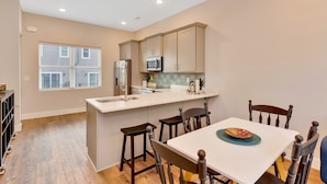 A modern kitchen with a central island, wooden chairs, and a dining table. - Near Coffee/Food, NOOGA NOOK 10 mins Chattanooga! (Chattanooga)
