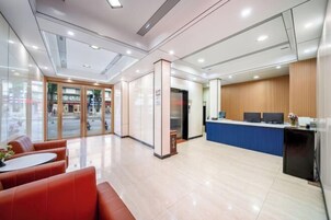 A modern reception area with a glass entrance, a reception desk, and seating area.
