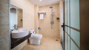 Un baño con lavamanos, inodoro y ducha.