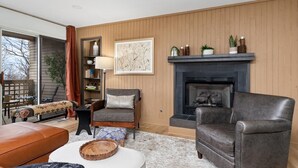 Ein Wohnzimmer mit Kamin, einer Couch, einem Couchtisch und einem Bücherregal.