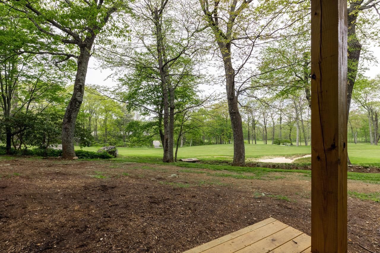 Une terrasse en bois avec vue sur un terrain de golf.