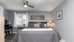 A bedroom with a bed, a desk, a chair, a ceiling fan, and a window with blinds. - Timbers Lodge 42 with Wintergreen Advantage (Wintergreen)
