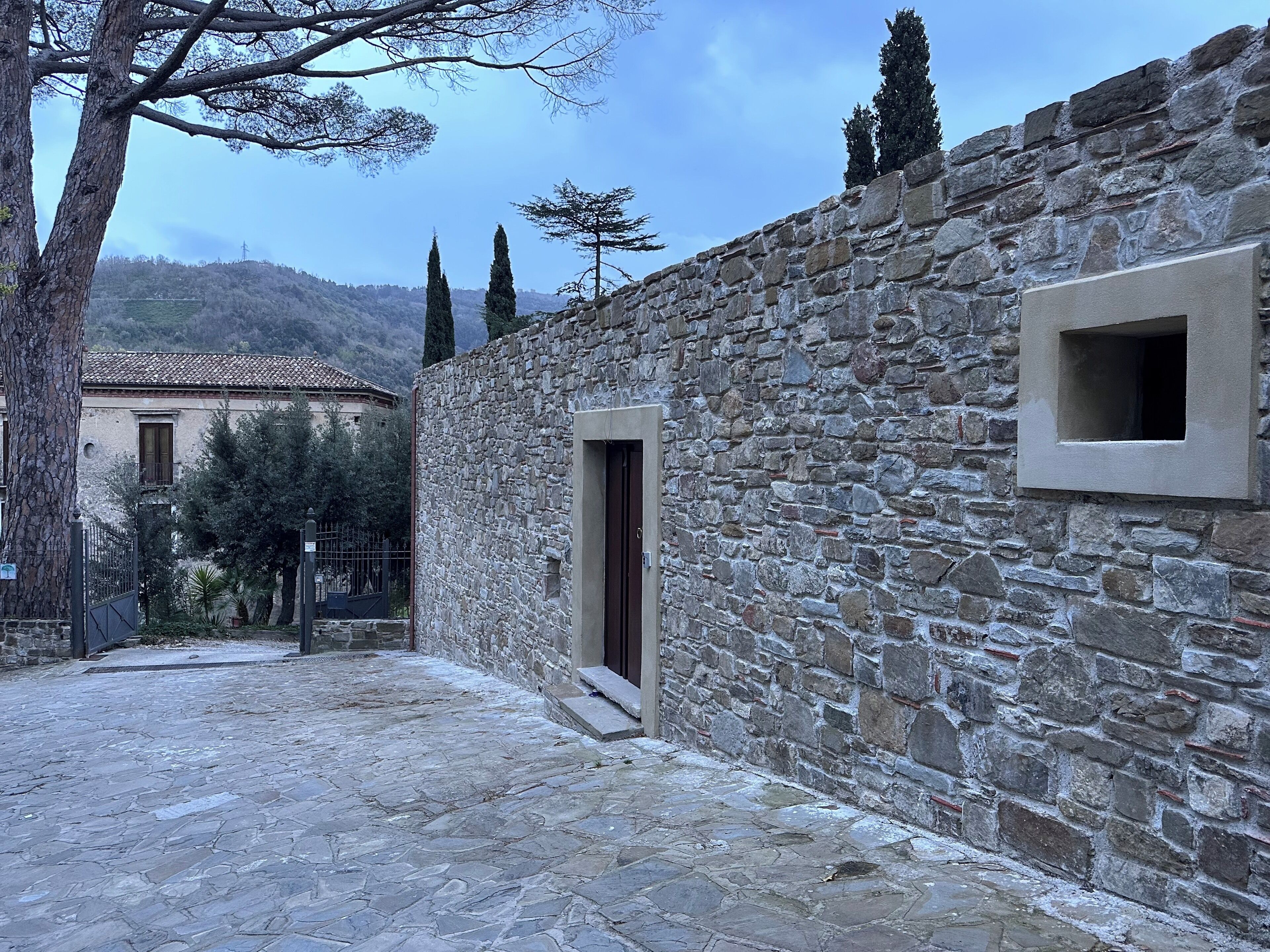 A stone building with a rustic exterior, a small window, and a door.