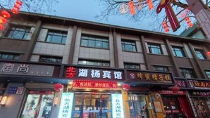 A building with multiple storefronts, including one with a prominent red sign.
