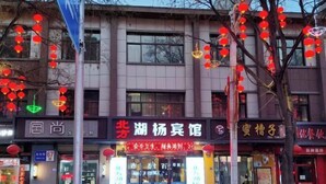 A building with multiple storefronts, including a pharmacy and a restaurant.