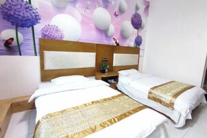 Habitación de hotel con dos camas, un cabecero de madera y una pared decorativa con flores y huevos.