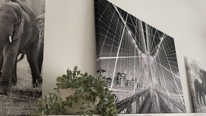 A wall with three framed artworks: a black and white elephant, a bridge, and a landscape. - 3 Bed House - Sleeps 5 - Garden - Parking - Wifi (Dartford)