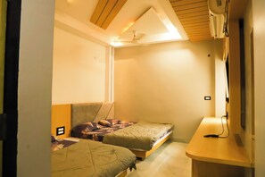 Two single beds with matching headboards, a desk, and shelf.