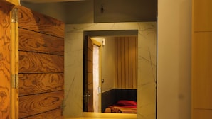 A bathroom with a wooden vanity, a marble sink, and a mirror. - Hotel Bholenath (Khandwa)