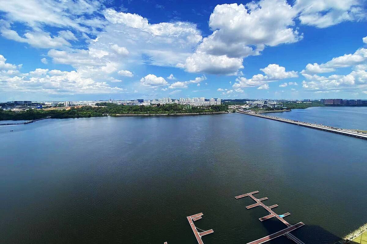 Une vue sur la ville, avec le front de mer, un ciel dégagé et une rivière paisible.
