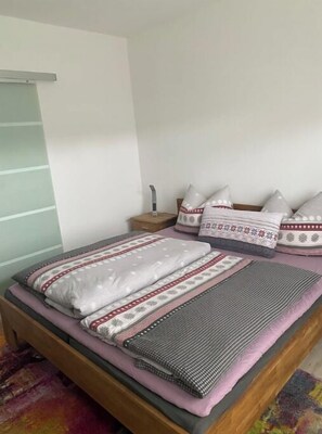 Enjoy a restful night's sleep in this inviting bed with a plush blanket and comfortable pillows.