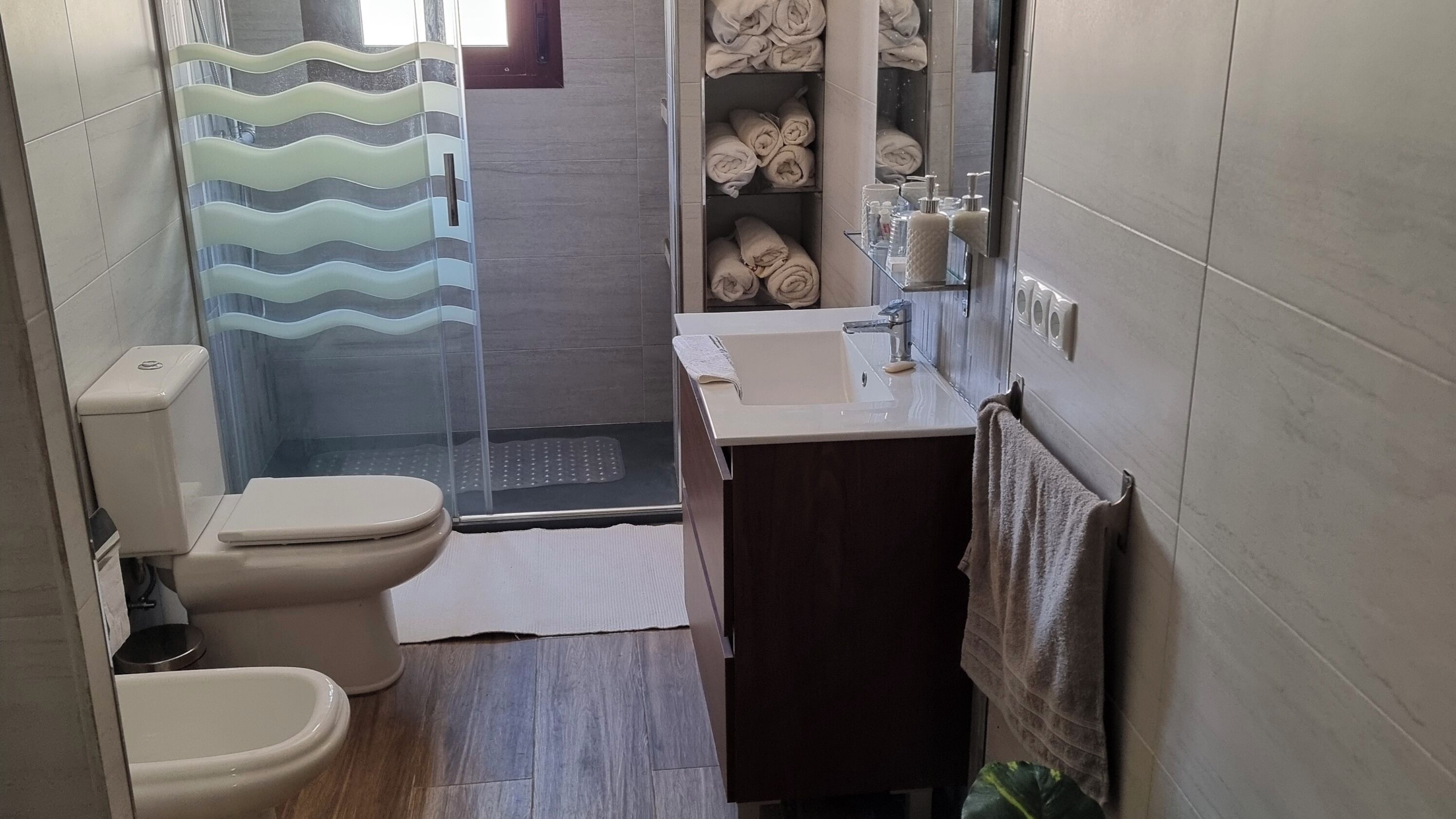 Ein Badezimmer mit Toilette, Waschbecken und Duschbereich.