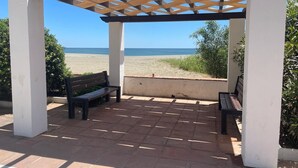 Eine hölzerne Pergola mit Bänken mit Blick auf einen Strand.