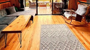 Un intérieur chaleureux avec des murs en bois, un canapé, un fauteuil à bascule et une table.