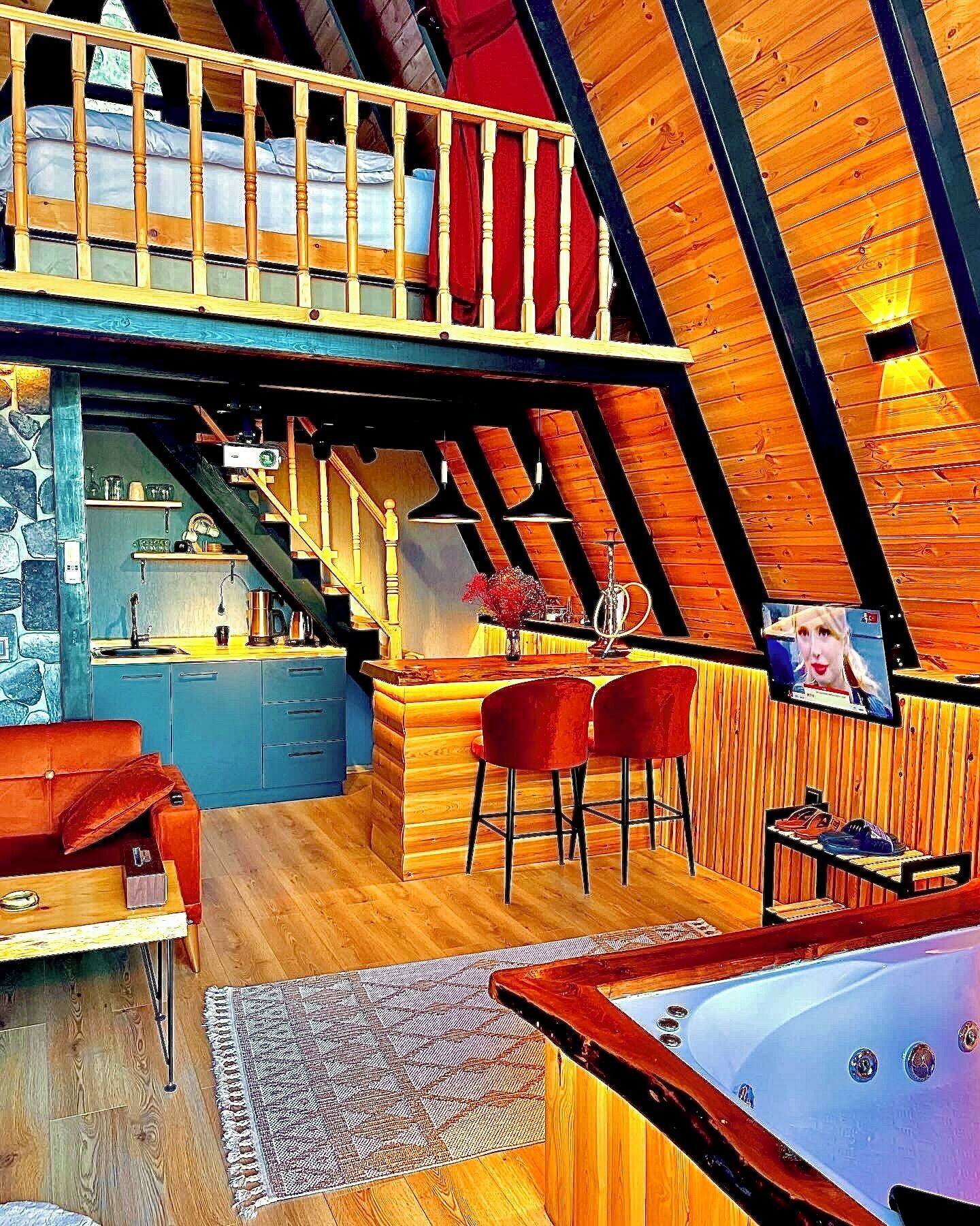 Un appartement chaleureux de style loft, comprenant une cuisine, un coin repas et un jacuzzi.