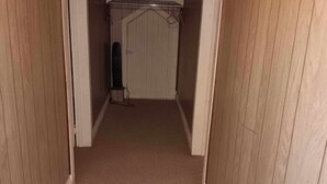 A narrow hallway with wooden walls and a carpeted floor, leading to a white door at the end. -  Farmhouse sleeps 2 -6  in the Allegheny National Forest outside Bradford Pa (Bradford)