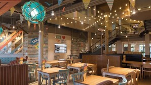 A restaurant interior with wooden tables and chairs, a staircase, and string lights. - Mablethorpe Lakeside Caravan With Decking & Wi-fi! (Mablethorpe)