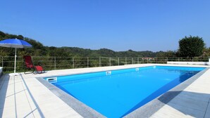 Piscina rectangular con superficie de agua azul cristalina, rodeada por un deck de color claro.
