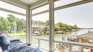 A spacious room with large windows overlooking a marina and water. - Exquisite Canal-front Home: Access to Lake Conroe! (Montgomery)