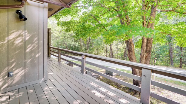 A wooden deck with a railing overlooking a forested area. - Bella Vista Townhome w/ Deck Near Back 40 Trail! (Bella Vista)