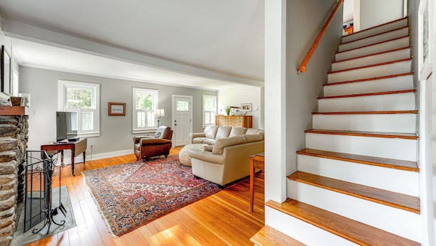A spacious living room with a fireplace, a staircase, and a large window. - 2 Mi to Dtwn: 2-acre Retreat w/ Large Yard! (Madison)