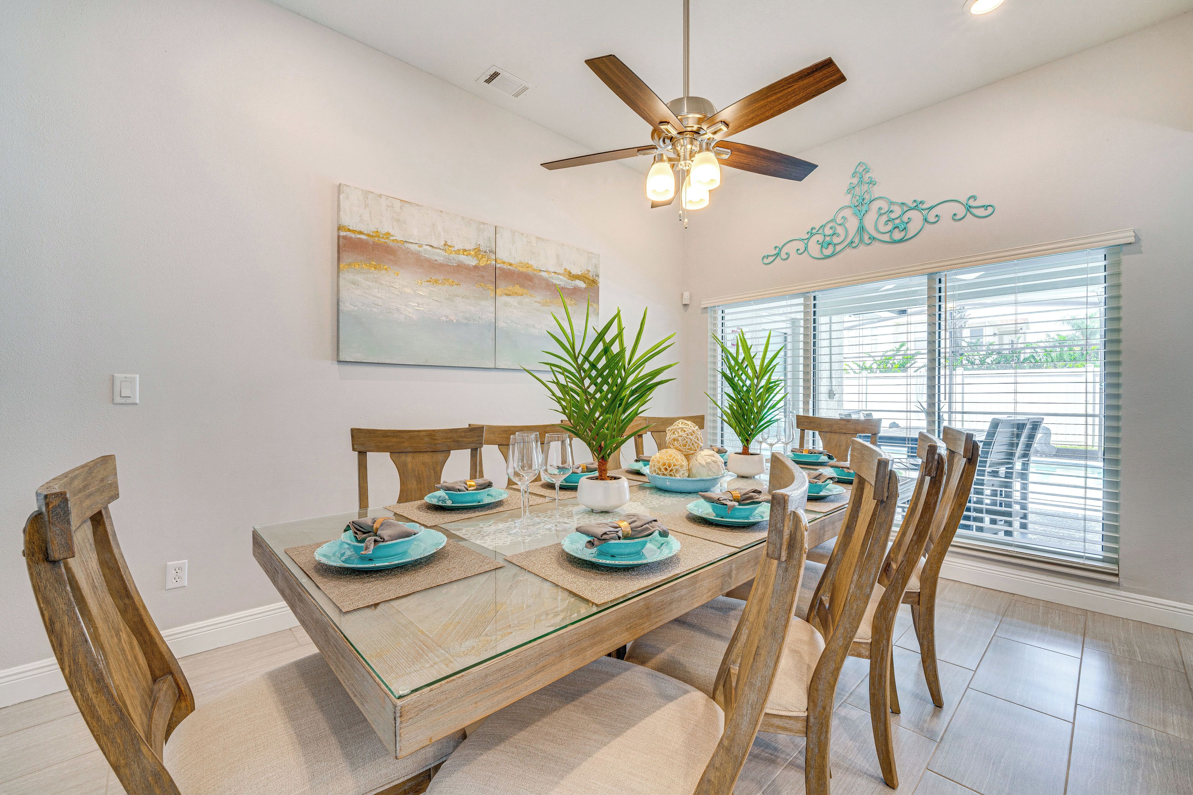 A dining area with a wooden table, chairs, and a ceiling fan.