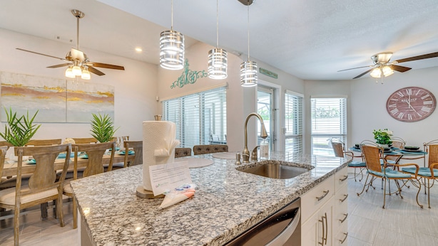 A modern kitchen with granite countertops, stainless steel appliances, and pendant lighting. - 5 Mi to Disney World: Spacious Kissimmee Home! (Kissimmee)