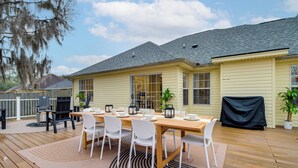 A covered patio with a wooden deck, a dining table set for six, and a grill area. - Savannah Haven w/ Gazebo, Grill & Fire Pit (Savannah)