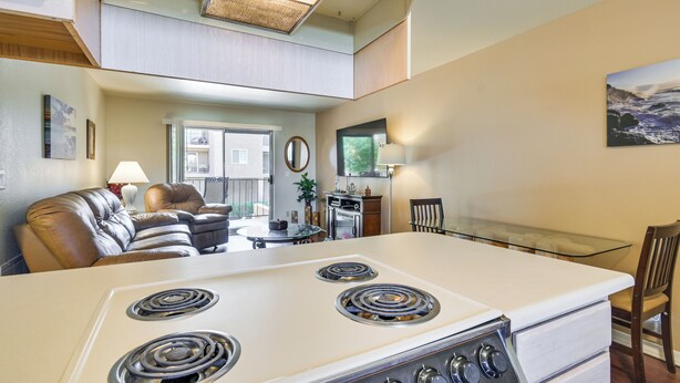 A kitchen with a stove, dining area, and seating.