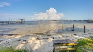 Ein Strand mit einer Holzbank und einem Gazebo.