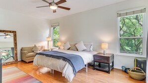 A bedroom with a bed, a nightstand, a dresser, a window, and a ceiling fan. - Deck & Greenbelt Access: Lovely Austin Home (Austin)