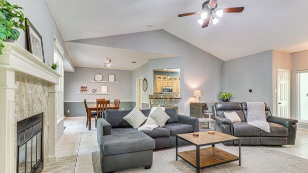 A spacious living room with a fireplace, a dining area, and a kitchen in the background. - Deck & Greenbelt Access: Lovely Austin Home (Austin)