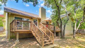 A two-story house with a wooden deck and stairs leading to a balcony. - Deck & Greenbelt Access: Lovely Austin Home (Austin)