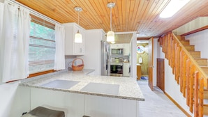 A kitchen with a wooden ceiling, white cabinets, a granite countertop, and a wooden staircase. - Community Perks! 'mtn Serenity Retreat' in Newland (Newland)
