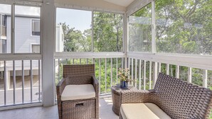 A covered porch with wicker furniture and a potted plant. - Holmes Beach Condo Near Anna Maria: Pool Access! (Holmes Beach)