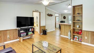 Relax in this inviting living area with a flat-screen TV, bookshelf, and comfortable seating.
