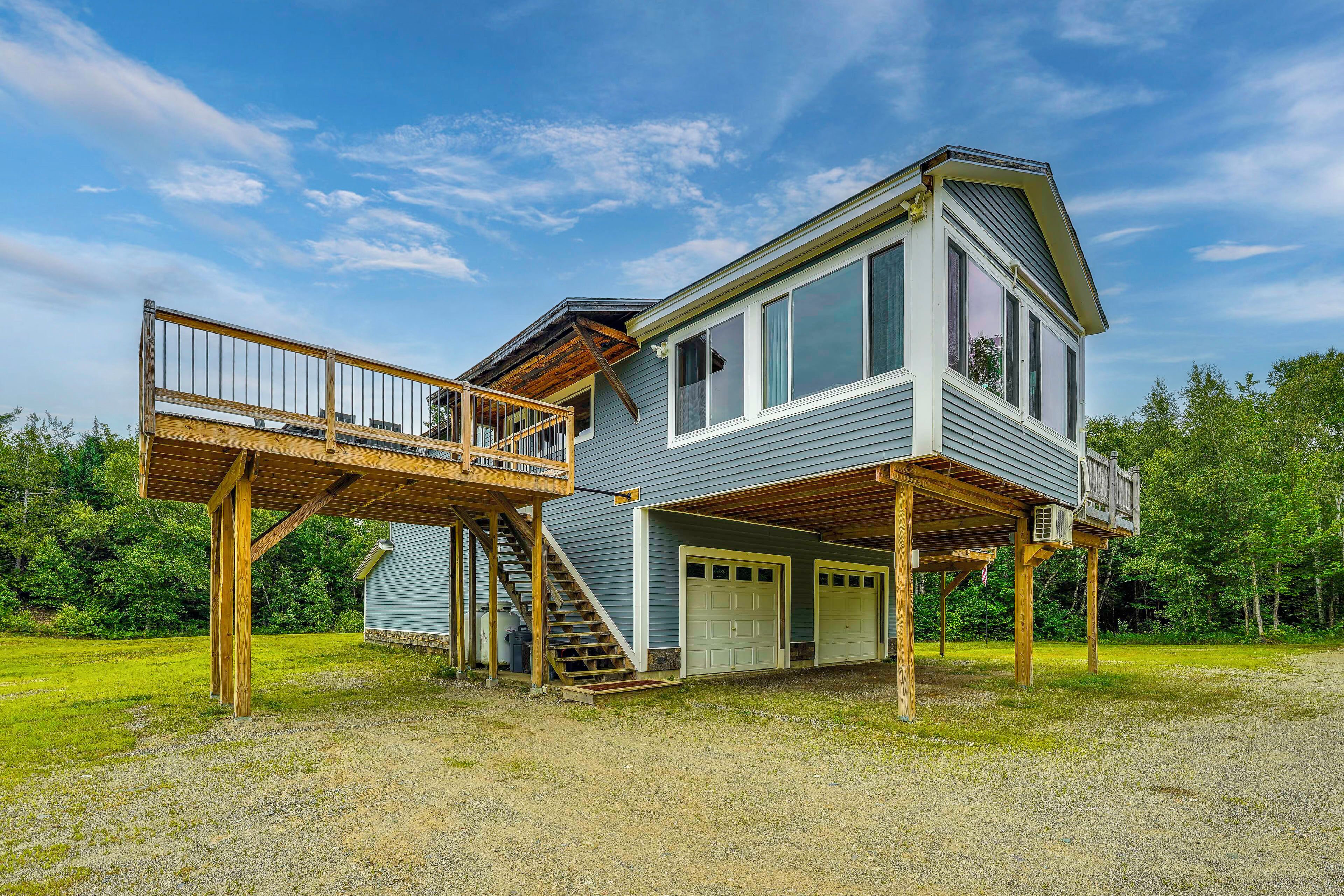 A two-story house with a wooden deck and a covered outdoor area.