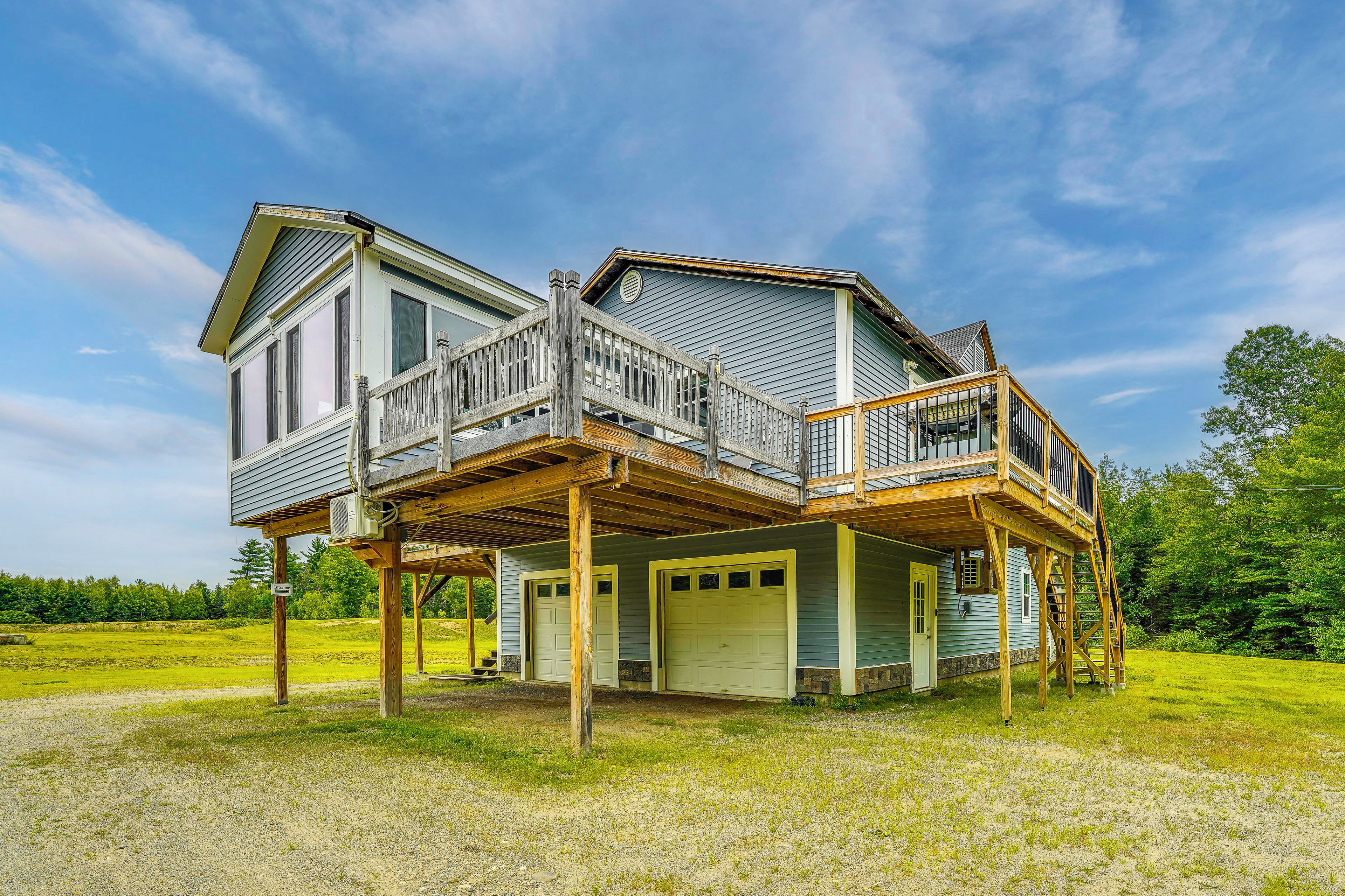A two-story house with a deck and a garage.