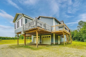A two-story house with a deck and a garage. - Mountain-view Maine Cabin: Ski, Hike & Bike! (Strong)