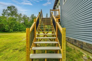 A wooden staircase leading to a house with a stone foundation. - Mountain-view Maine Cabin: Ski, Hike & Bike! (Strong)