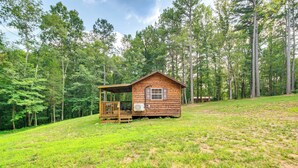A wooden cabin with a porch, surrounded by a forested area. - Serene Clarkson Cabin ~ 4 Mi to Nolin Lake Access! (Clarkson)