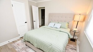 A bedroom with a bed, a bedside lamp, and a door. - 5 min walk to Notre Dame! Modern home (517) (South Bend)