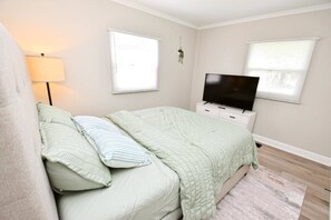 A bedroom with a bed, a TV, and a lamp. - 5 min walk to Notre Dame! Modern home (517) (South Bend)