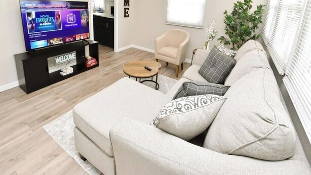 A living room with a sofa, a coffee table, a TV on a stand, and a small side table. - 5 min walk to Notre Dame! Modern home (517) (South Bend)
